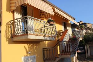 um edifício amarelo com varandas e flores em Poggio dell’Ortolano em Monsummano