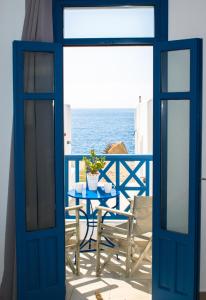 a blue door leading to a balcony with the ocean at Alisachni Villas in Lefkos Karpathou