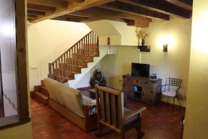 a living room with a couch and a staircase at Complejo Rural Las Palomas in Jerte