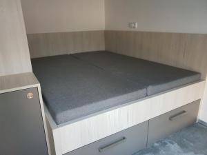 カールスボリにあるApartmán Pod Medvědí horouのマットレス付きの小さな部屋のベッド1台分です。