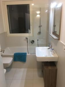 a bathroom with a sink and a tub and a toilet at Appartamento Ligeia in Bolzano +36 photos