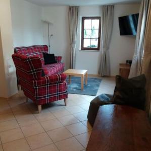ein Wohnzimmer mit einem roten Sofa und einem Tisch in der Unterkunft Ferienwohnung Wolf in Oberschöna