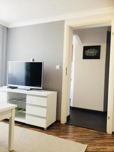 una sala de estar con TV en una cómoda blanca en Apartament Na Starówce VII en Pszczyna