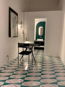 a room with a table and a chair on a tiled floor at PrimoPianoPosillipo in Naples