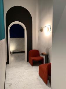 a hallway with a red chair and a lamp at PrimoPianoPosillipo in Naples