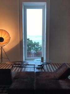 a living room with a couch and a large window at PrimoPianoPosillipo in Naples
