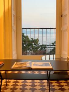 a table with a book on it in front of a window at PrimoPianoPosillipo in Naples