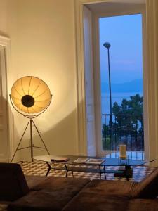a living room with a table and a large window at PrimoPianoPosillipo in Naples
