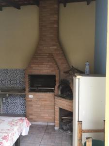 a room with a brick fireplace in a room at Suíte em Caraguá in Caraguatatuba