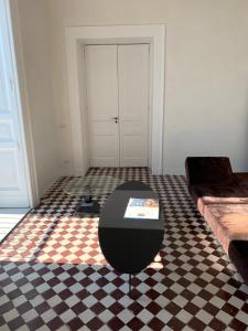 a room with a black table and a checkered floor at PrimoPianoPosillipo in Naples