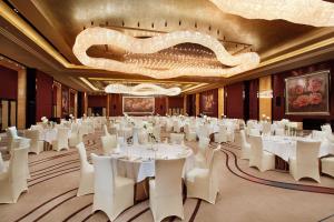 un salón de banquetes con mesas blancas y sillas blancas en Mels Weldon Dongguan Humen en Dongguan
