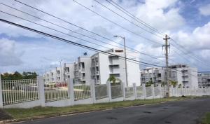 a white fence in front of a building at Relaxing Hillside Village Apartment in Rio Grande