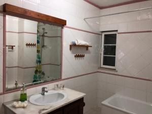 een badkamer met een wastafel, een spiegel en een bad bij Villa Do Mar SW in Zambujeira do Mar +76 foto's