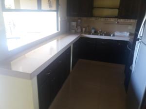 a kitchen with black cabinets and a sink and a window at Pacandé Apartamentos in Boquete