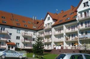 un grande condominio con auto parcheggiate davanti di Podczele BLISKO PLAŻY a Kołobrzeg