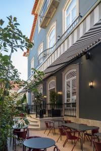 un patio con mesas y sillas frente a un edificio en Oporto Serviced Apartments - Cedofeita, en Oporto