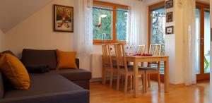 uma sala de estar com um sofá e uma mesa de jantar em Yellow apartma Kranjska Gora em Kranjska Gora