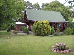 a log cabin with a yard in front of it at Ferienhaus I.Winkler in Neukalen