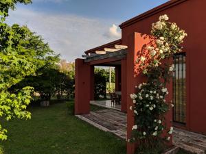 a garden entrance to a red house with flowers on it at La Colorada in San Pedro