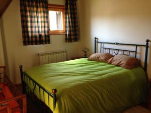 una camera da letto con un grande letto verde con finestra di Casas do Trabulo a Decermilo