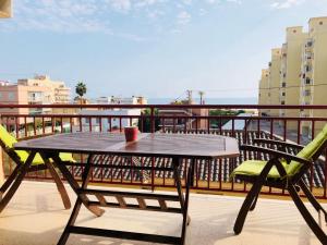 - Balcón con mesa de madera y 2 sillas en Apartamento, en El Perelló