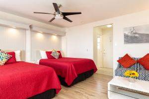 a bedroom with two beds and a ceiling fan at The Sea View Inn At The Beach in Manhattan Beach