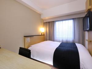 a hotel room with a bed and a television at APA Hotel Ikebukuro Eki Kitaguchi in Tokyo