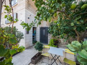 un patio con 2 bancos amarillos y una puerta negra en Bat Galim Boutique Hotel, en Haifa