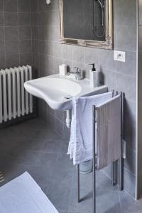uma casa de banho com um lavatório branco e um espelho. em Nebbialuce b&b em Lessona