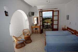 a bedroom with a bed and a table and a table at Pirgos Naxos in Aliko Beach
