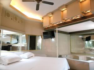 a bedroom with a bed and a tub and a tv at El Gran Marques Hotel/Motel in Río Blanco