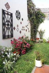 a garden with flowers on the side of a building at Calida casa ph, con patio in Florida