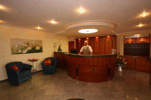 a man standing at a bar in a waiting room at Hotel Pension Fent in Bad Füssing