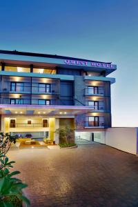 a guest house with a large courtyard in front of it at Quest Hotel Kuta by ASTON in Kuta