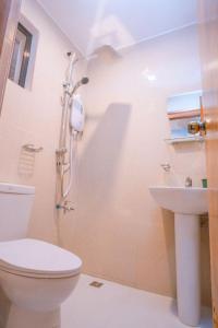 een badkamer met een toilet en een wastafel bij Argamosa Bayside Inn in Coron