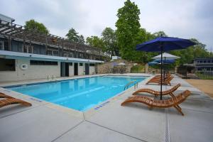 a swimming pool with lounge chairs and an umbrella at Allenberry Resort in Carlisle