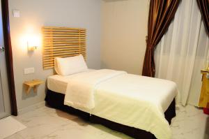 een kleine slaapkamer met een bed en een raam bij HOTEL MESRA ALOR SETAR in Alor Setar