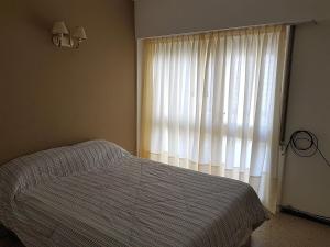 1 dormitorio con cama y ventana grande en Depto. c/balcón, Colón y Olavarría en Mar del Plata