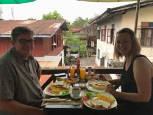 a man and a woman sitting at a table with food at Liberty Place in Luang Prabang