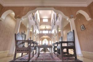 a hallway with chairs and a table in a building at Riad Dar Bab Todra in Tinerhir