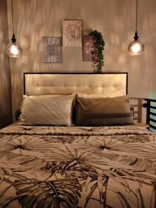 a bedroom with a large bed with two lights at Shofiya Guesthouse Solo in Solo