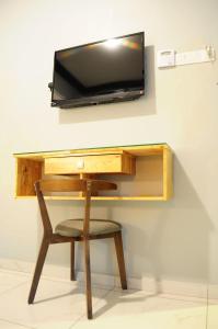 a desk with a chair and a television on a wall at HOTEL MESRA ALOR SETAR in Alor Setar