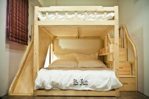 a wooden bunk bed in a room at Siamo in Tainan