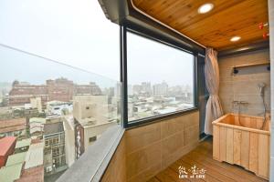 a bathroom with a large window and a view of the city at Siamo in Tainan