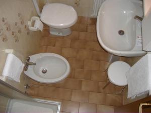 a bathroom with a toilet and a sink at Residence Hotel Montechiara in Baselga di Pinè +31 photos