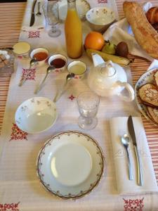 une table avec des assiettes et des ustensiles dans l'établissement Le Rézinet - Chambres d'Hôtes, à Marcilly le Chatel