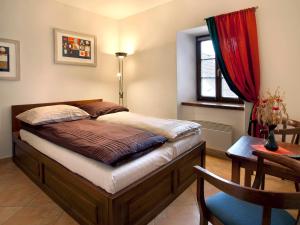 1 dormitorio con cama, mesa y ventana en Staroměstský Penzion, en Tábor