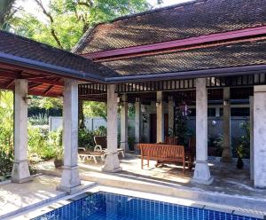 a pavilion with a bench next to a swimming pool at Sabai Private Pool Villa Khao Lak in Khao Lak