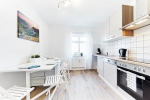 une cuisine blanche avec un comptoir et une table dans l'établissement Wohnung 5 - nur 5-10 min vom Europapark, à Ettenheim