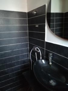 Baño negro con lavabo y espejo en Appartement le Citronnier, en Sainte-Anne